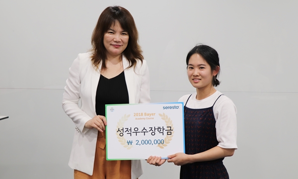 정현진 바이엘코리아 동물의약사업부 대표(왼쪽)가  성적 최우수자 김다미 수의사(오른쪽)에게 장학금을 수여했다